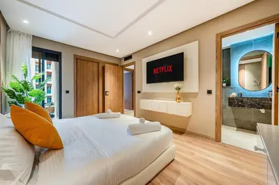 a bedroom with a bed and a tv on the wall at Appartement Neuf et luxueux de 3 chambres proche du centre ville in Marrakech