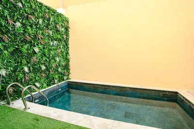 a swimming pool in front of a green wall at 5-Star Duplex - Private Pool in Marrakech