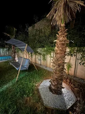 a palm tree next to a hammock and an umbrella at Luxury Villa Marrakech in Marrakech