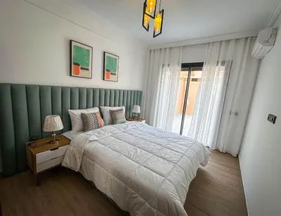 a bedroom with a large bed and a window at Well equipped luxury apartment in centre marrakech ctm aeroport train medina in Marrakech