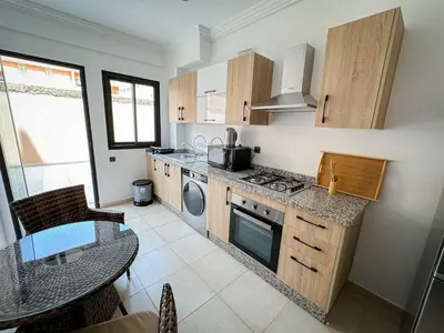 a kitchen with a table and a stove top oven at Well equipped luxury apartment in centre marrakech ctm aeroport train medina in Marrakech