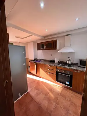 a kitchen with wooden cabinets and a stove top oven at Appartement Majorelle in Marrakech