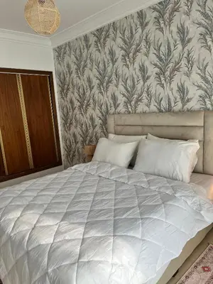 a bedroom with a large white bed with a wallpaper at Appartement Majorelle in Marrakech