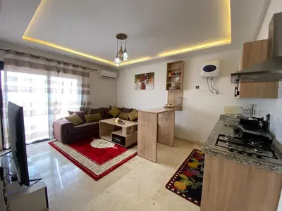 a kitchen and living room with a couch and a table at Hivernage & Gueliz Luxury Apt Pool near medina in Marrakech