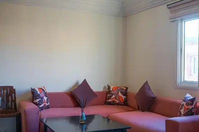 a living room with a red couch and a table at appartement en résidence in Marrakech