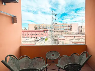 a balcony with chairs and a view of a city at Oasis Gueliz - Piscine & parking privé in Marrakech