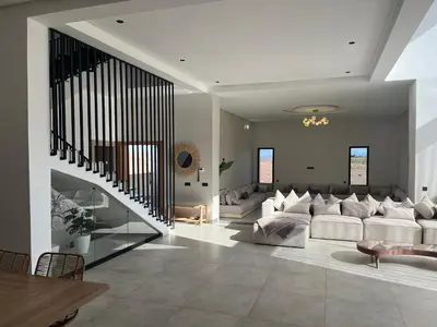 a living room with white furniture and a staircase at Villa Lam in Marrakech