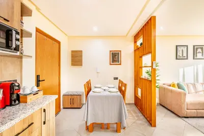 a kitchen and living room with a table and a couch at Warm Nest 8 Comfort And Luxury in Oulad Akkou