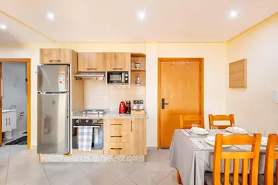 a kitchen with a table and a stainless steel refrigerator at Warm Nest 8 Comfort And Luxury in Oulad Akkou
