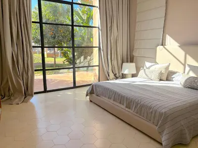 a bedroom with a bed and a large window at Palais Meryem in Marrakech