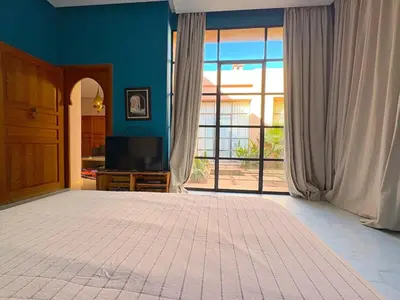 a living room with a large window and a television at Palais Meryem in Marrakech