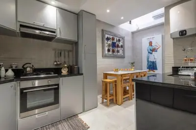 a kitchen with stainless steel appliances and a table at Dar Choway Ground Floor Apartment in Marrakech