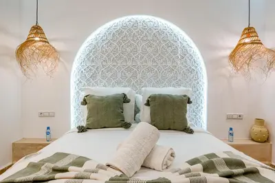 a bedroom with a bed with a white headboard at Riad Exotika a Oasis with Pool, 7 min to Jemaa El Fna in Marrakech
