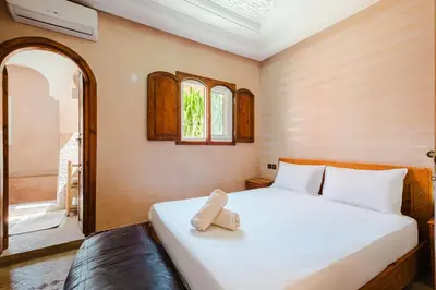 a bedroom with a bed and a window at Riad Marrakech Oasis complexe in Marrakech