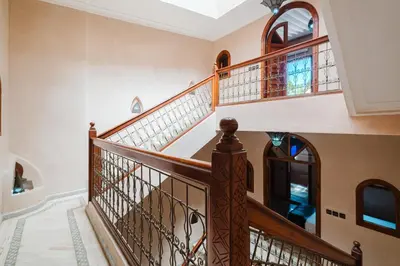 a staircase in a home with wooden railings at Riad Marrakech Oasis complexe in Marrakech