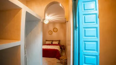 a hallway with a bed in a room with a door at riad Orazur in Marrakech