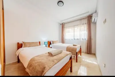 a bedroom with two beds and a window at gueliz central & Moderne in Tamazouzte