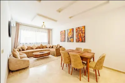 a living room with a table and chairs and a couch at gueliz central & Moderne in Tamazouzte