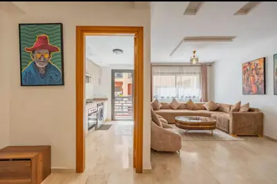 a living room with a couch and a table at gueliz central & Moderne in Tamazouzte