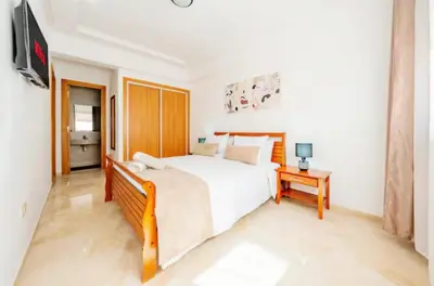 a bedroom with a bed and a tv in it at gueliz central & Moderne in Tamazouzte