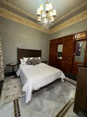 a bedroom with a large bed and a chandelier at Golf mountain camels sereine holiday treat in Marrakech