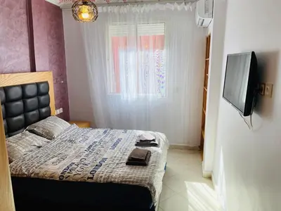 a bedroom with a bed and a flat screen tv at Moroccan-style apartment rental in Marrakech in Marrakech