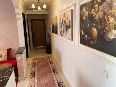 a hallway with paintings on the wall and a red couch at Moroccan-style apartment rental in Marrakech in Marrakech