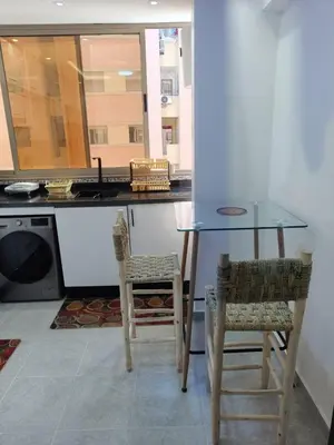 a kitchen with a glass table and two chairs at arrive as a guest , turn to a local in Marrakech