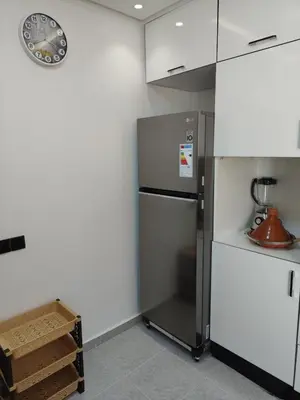 a kitchen with a refrigerator and a clock on the wall at arrive as a guest , turn to a local in Marrakech
