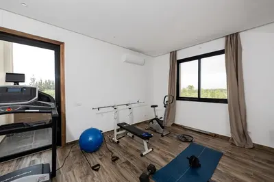 a room with a gym with a treadmill and a blue ball at Prestige home