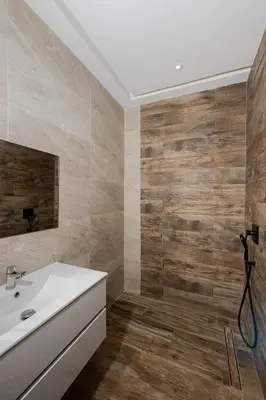 a bathroom with a white sink and wooden walls at Prestige home