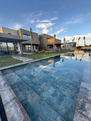 a swimming pool in front of a house at Prestige home