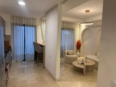 a living room with a couch and a table at Luxury Noria Apartment - Pool - Security - airport in Oulad Akkou