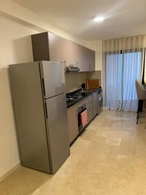 a kitchen with a stainless steel refrigerator and a stove at Luxury Noria Apartment - Pool - Security - airport in Oulad Akkou