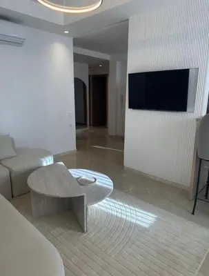 a living room with a couch and a table at Luxury Noria Apartment - Pool - Security - airport in Oulad Akkou