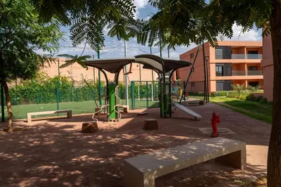 a park with a playground with a swing at Amal Cozy - Modern Design, 4 Pools & HD Wifi in Marrakech