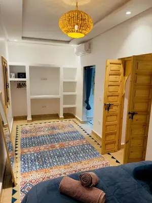 a room with a bed and a rug on the floor at Riad Marhaba in Marrakech