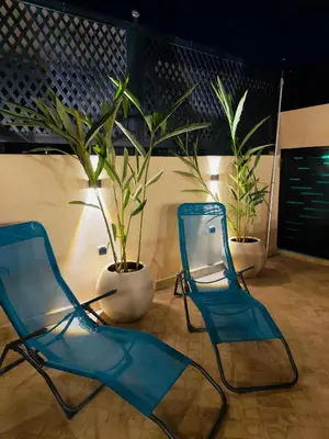 two blue chairs sitting in a room with plants at Riad Marhaba in Marrakech