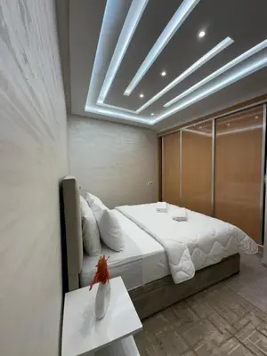 a bedroom with a large bed and a table at Chic appartement Marrakech in Marrakech