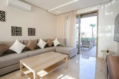 a living room with a couch and a table at The Calm Haven - Marrakech - Prestigia in Marrakech