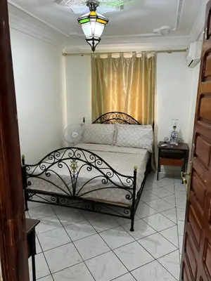a bedroom with a bed with a lamp and a window at Ryad Karima in Marrakech