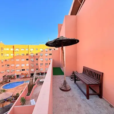 a patio with a bench and an umbrella on a balcony at Meriso Downtown Free Parking in Marrakech