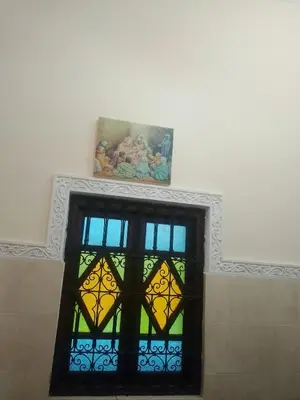 a stained glass window on a wall with a painting at House of Diamonds in Marrakech