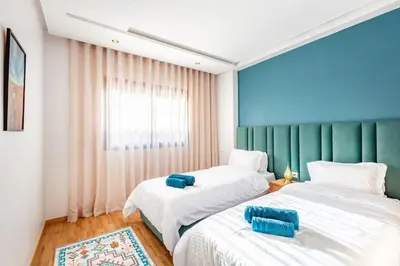 a bedroom with two beds and a window at Guéliz I Blue Mirage I Crafts and modernity in Marrakech