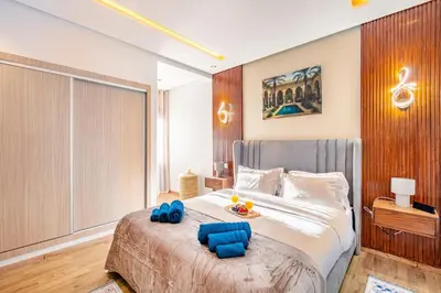 a bedroom with a large bed with blue pillows on it at Guéliz I Blue Mirage I Crafts and modernity in Marrakech