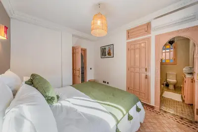 a bedroom with a large bed and a bathroom at Villa Chahrazad - 8prs - Piscine - Wifi in Marrakech