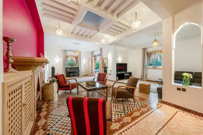 a living room with pink walls and chairs at Villa Chahrazad - 8prs - Piscine - Wifi in Marrakech