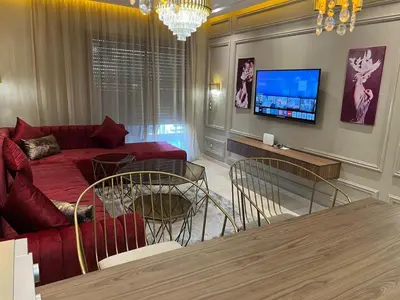 a living room with a red couch and a tv at Modern apartment with pool view, Kech in Marrakech
