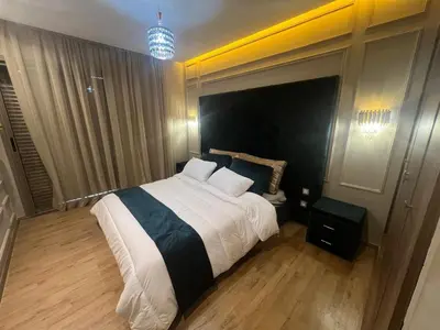 a bedroom with a large bed with a black headboard at Modern apartment with pool view, Kech in Marrakech