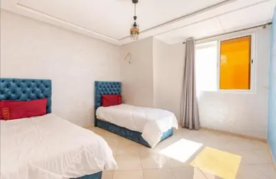 a bedroom with two beds and a window at appartement 2 chabres marrakech in Marrakech